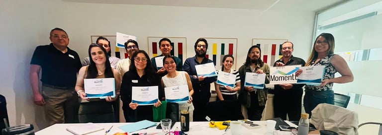 Group of people holding certificates posing for a photo in an office setting